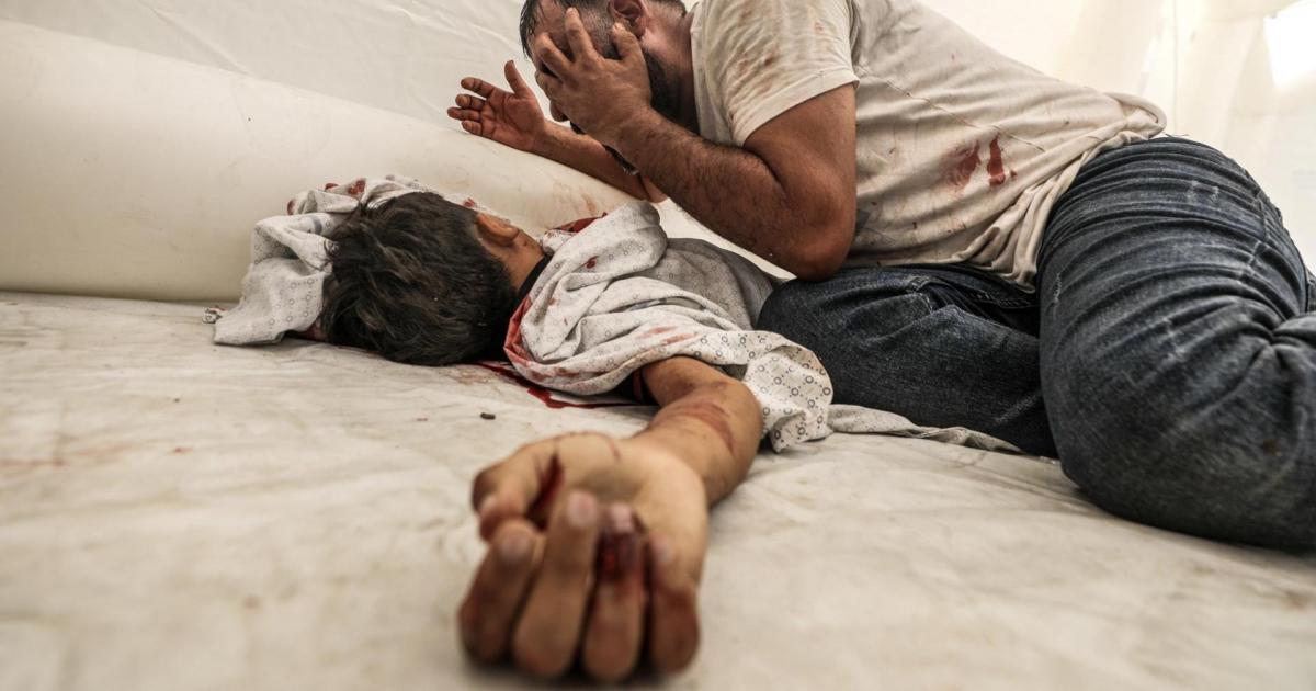 Un padre palestino llora sobre el cadáver su hijo fallecido en los bombardeos de Israel en represalia por el ataque de Hamás, en el hospital Al-Shifa.