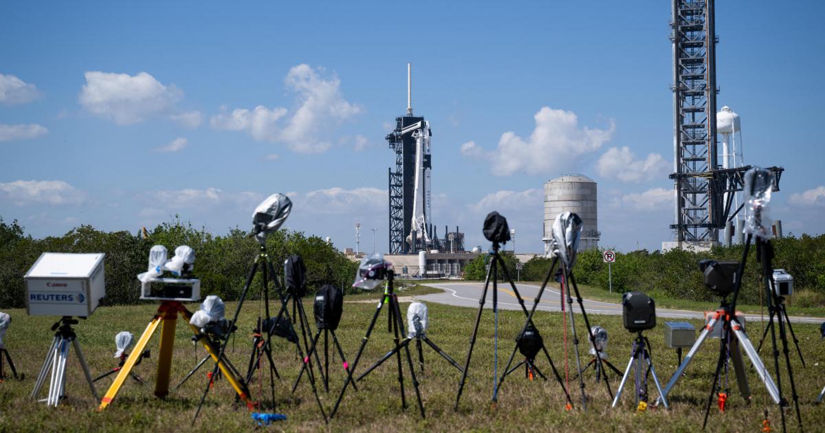 Fotografía cedida por la NASA donde se aprecian una cámaras instaladas por miembros de los medios informativos frente al cohete Falcon 9 de SpaceX con la nave espacial Dragon en la parte superior el sábado 25 de febrero en la plataforma de lanzamiento 39A en el Centro Espacial Kennedy de la NASA en Florida