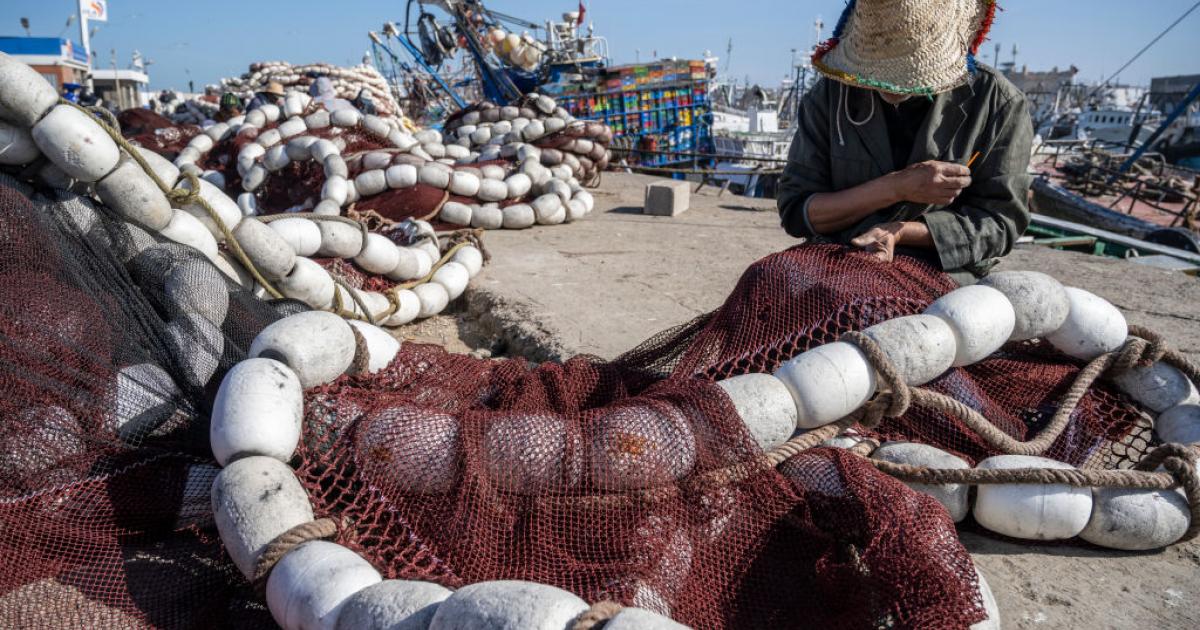Un pescador cose las redes en el puerto de Essaouira, Marruecos.