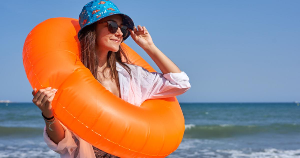 Una chica se coloca las gafas de sol junto al mar en una imagen de archivo.