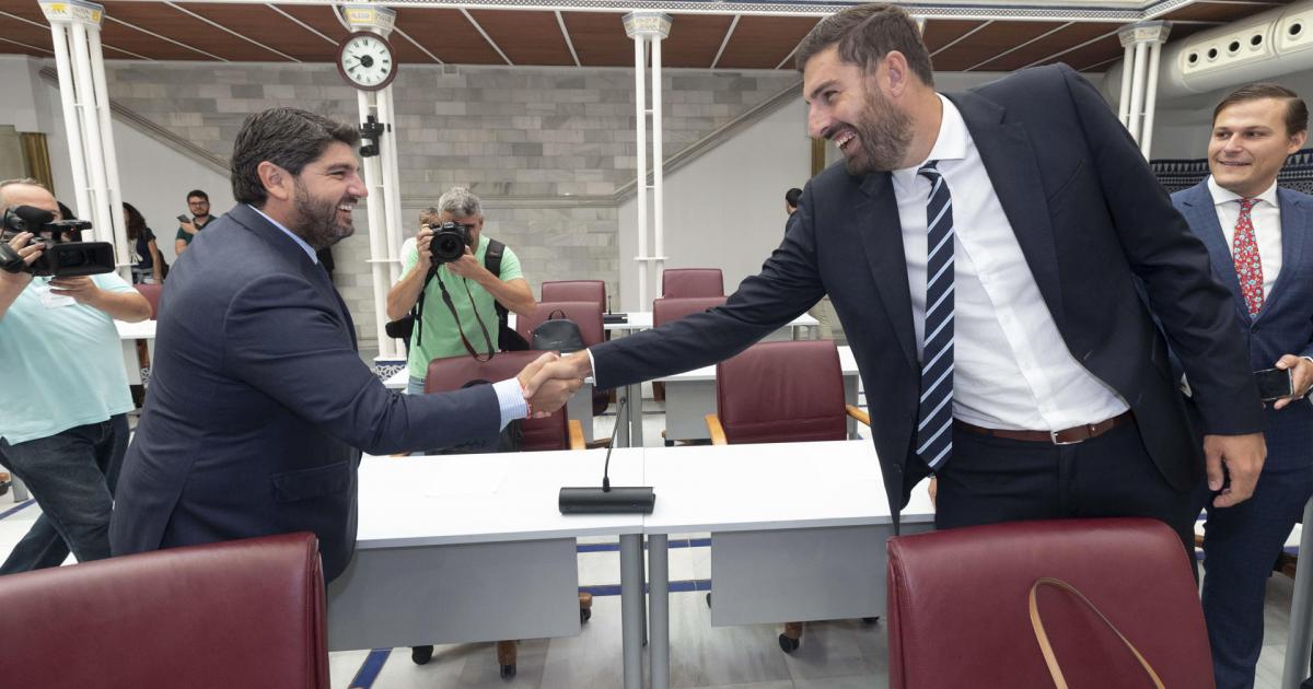 El presidente reelecto de Murcia, Fernando López Miras, saluda al portavoz de Vox en el parlamento murciano, José Ángel Antelo, a su llegada a la segunda sesión del pleno de investidura.