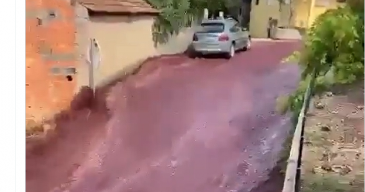Captura del vídeo en el que se ve una calle inundada de vino tinto.