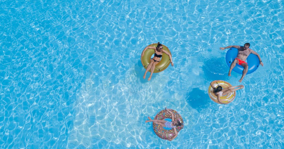 Imagen de archivo de una familia en una gran piscina.