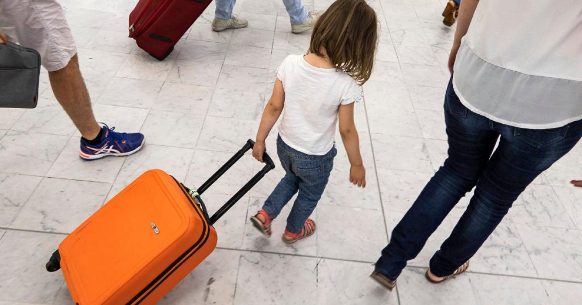 Una niña arrastra su maleta de mano por un aeropuerto en Europa.