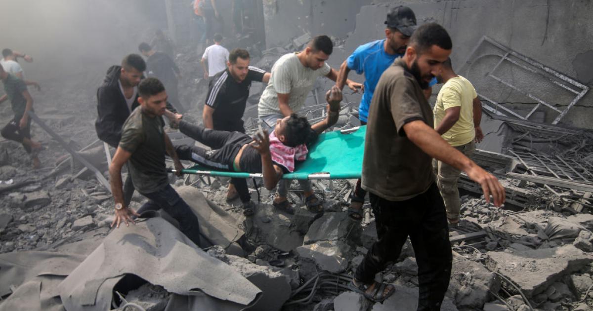 Varias personas rescatan a un herido tras un bombardeo en Gaza