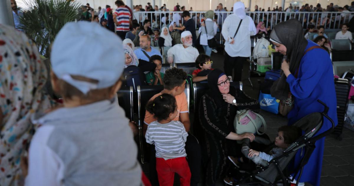 Personas esperando en el paso de Rafah