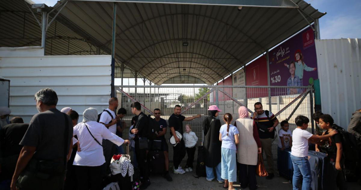 Un grupo de palestinos apostados en el paso de Rafah con la esperanza de cruzar a Egipto.