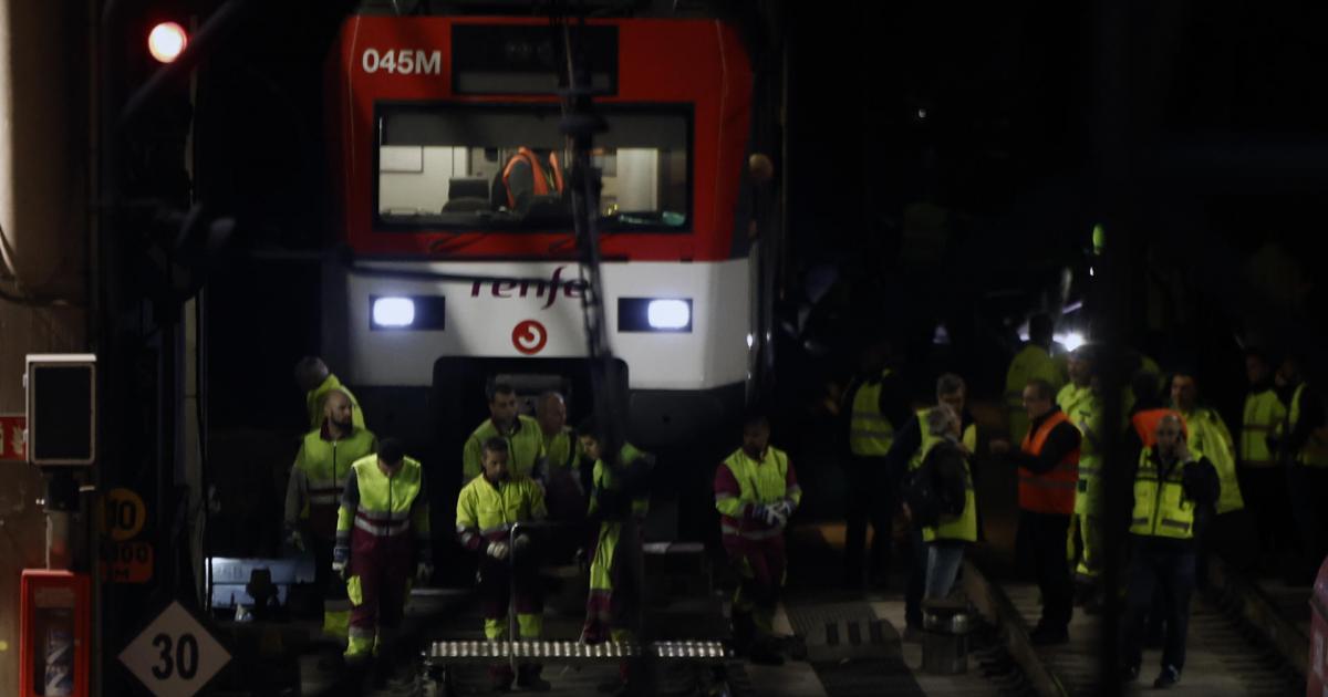 Varios operarios junto al tren de Cercanías que ha descarrilado este martes