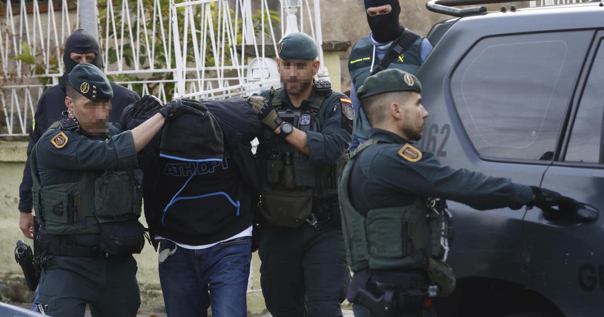 Agentes de la Guardia Civil y de los Mossos d'Esquadra custodian a uno de los detenidos en Martorell (Barcelona).