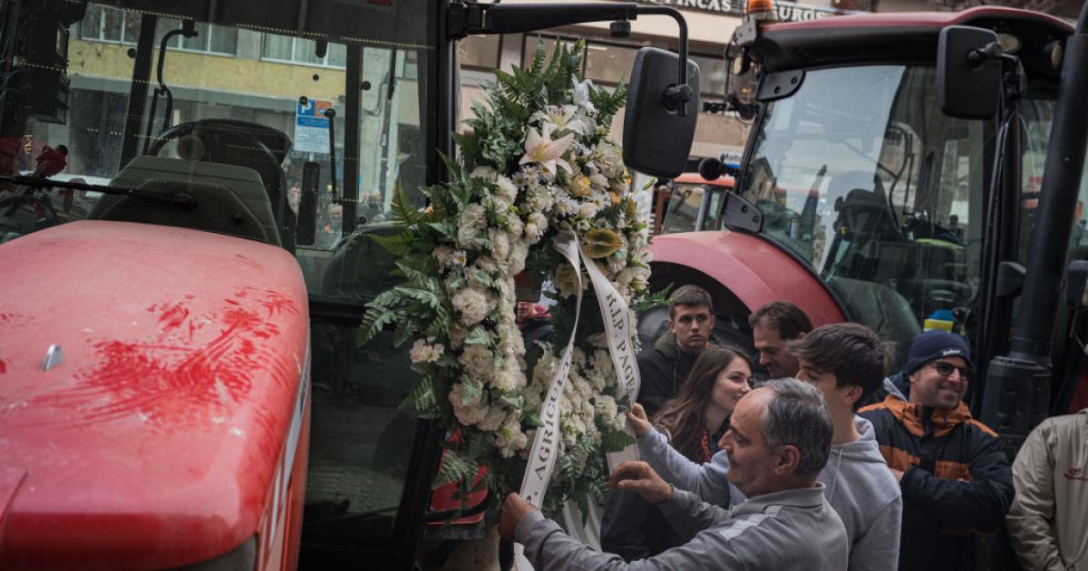 Un trabajador del campo coloca una corona fúnebre en su tractor durante unas protestas en Cataluña