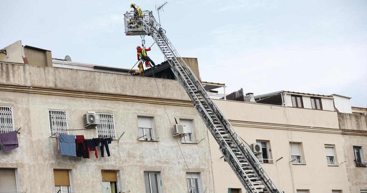 Los bomberos inspeccionan el interior de un edificio de cinco pisos, el bajo y otros cuatro, que se ha derrumbado en la calle Canigó de Badalona (Barcelona), al haber cedido el forjado de la construcción.