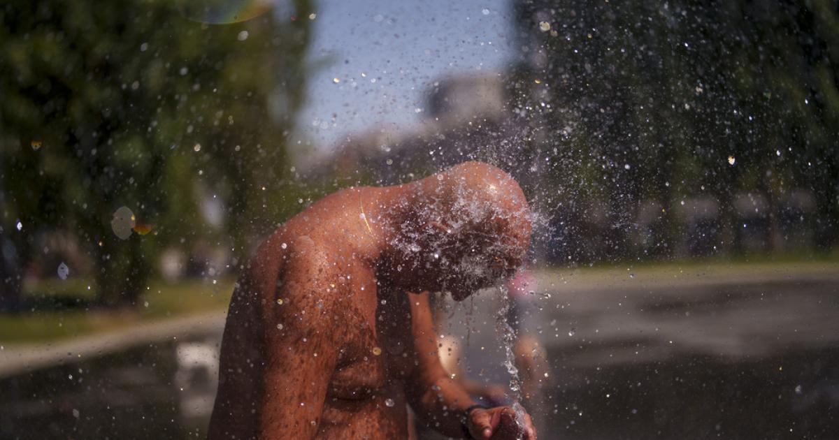 Un hombre se refresca con agua en Madrid en la primera ola de calor del verano de 2023.