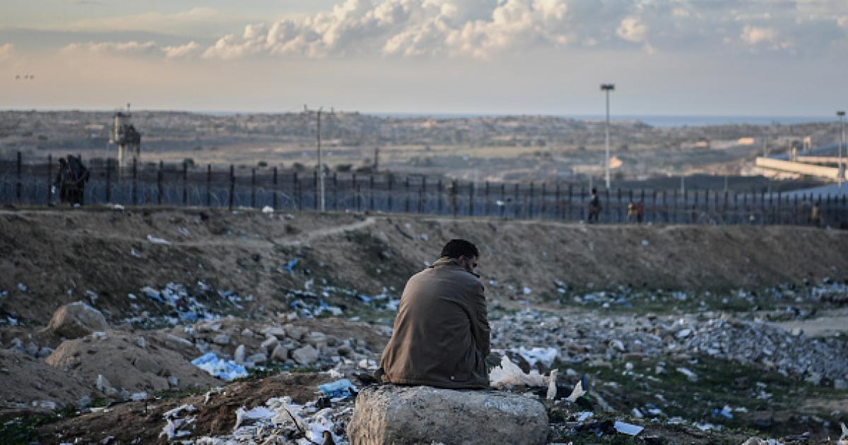 Un palestino aguarda sentado en las inmediaciones de Rafah.
