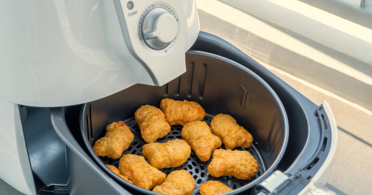 Imagen de archivo de una freidora de aire, con 'nuggets' de pollo.