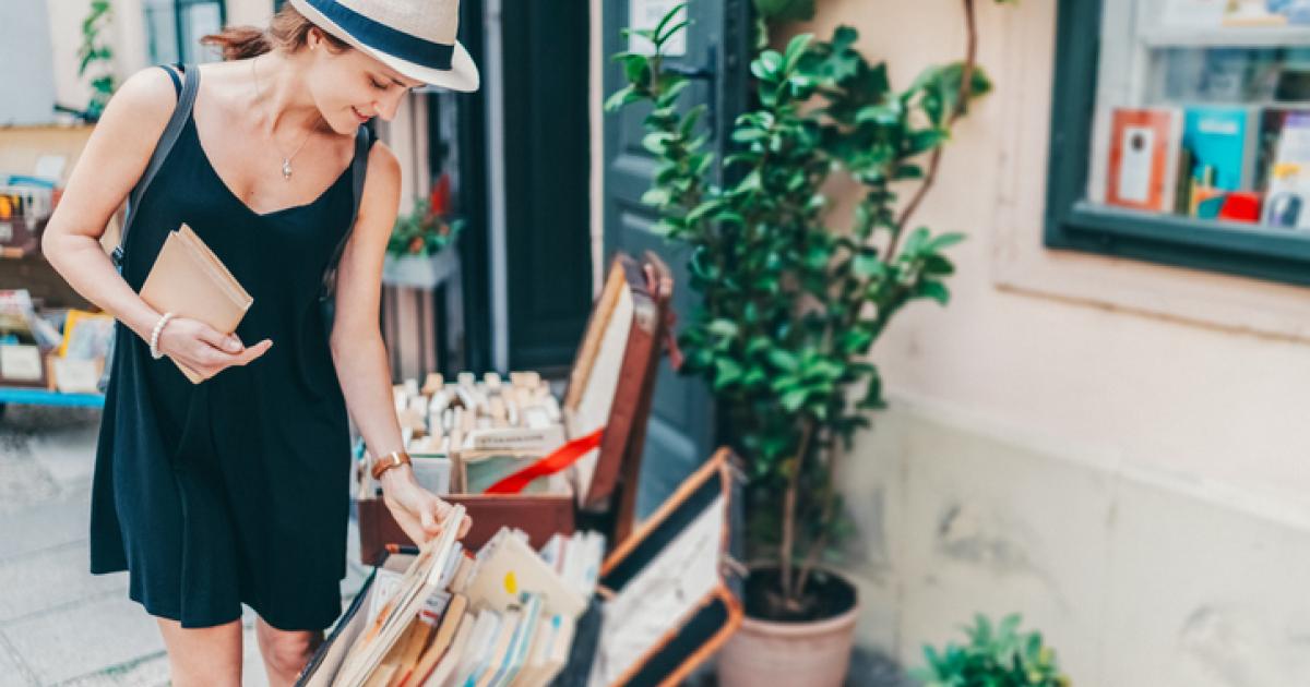 Imagen de una mujer ojeando libros de segunda mano.