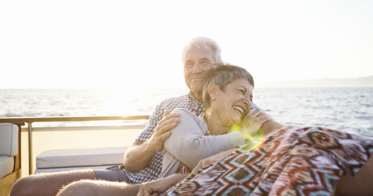 Dos personas mayores disfrutando de un viaje en el mar.