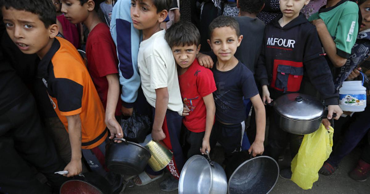 Imagen de archivo de varios niños gazatíes haciendo cola para recibir comida de la escasa ayuda humanitaria que ha logrado llegar a la Franja.