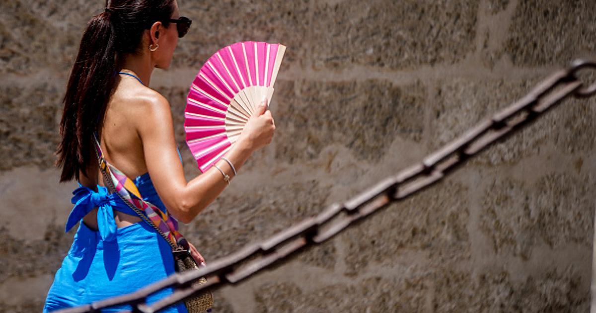 Imagen de archivo de una persona con un abanico, en las calles de Sevilla (Andalucía), en plena ola de calor.