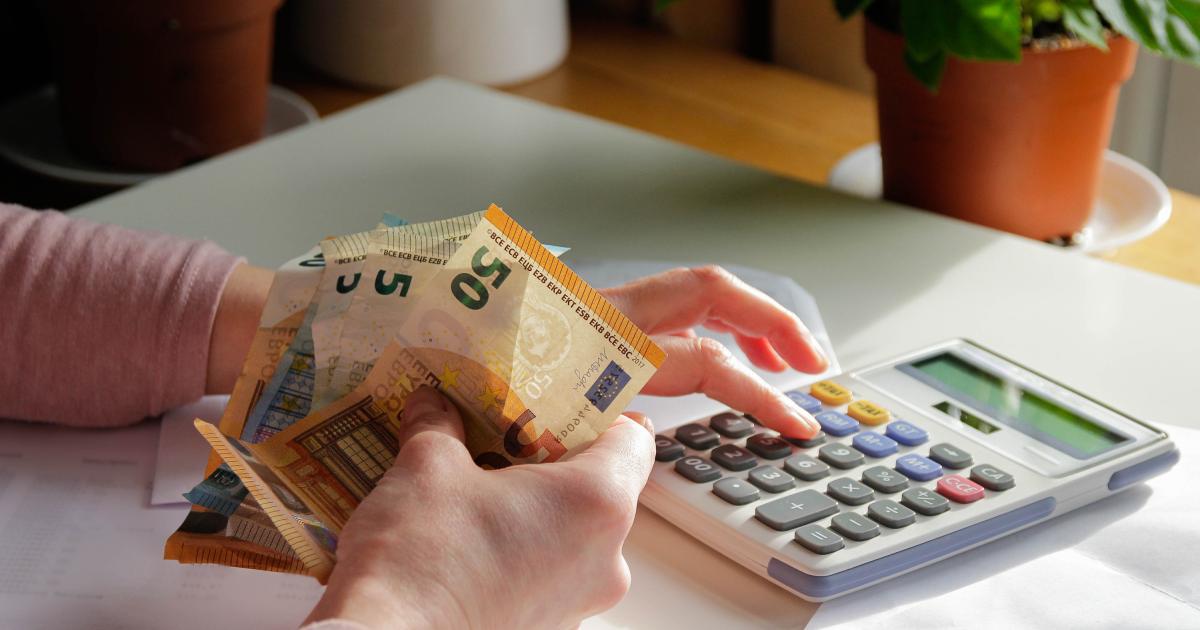 Una mujer echando cuentas con billetes en la mano.