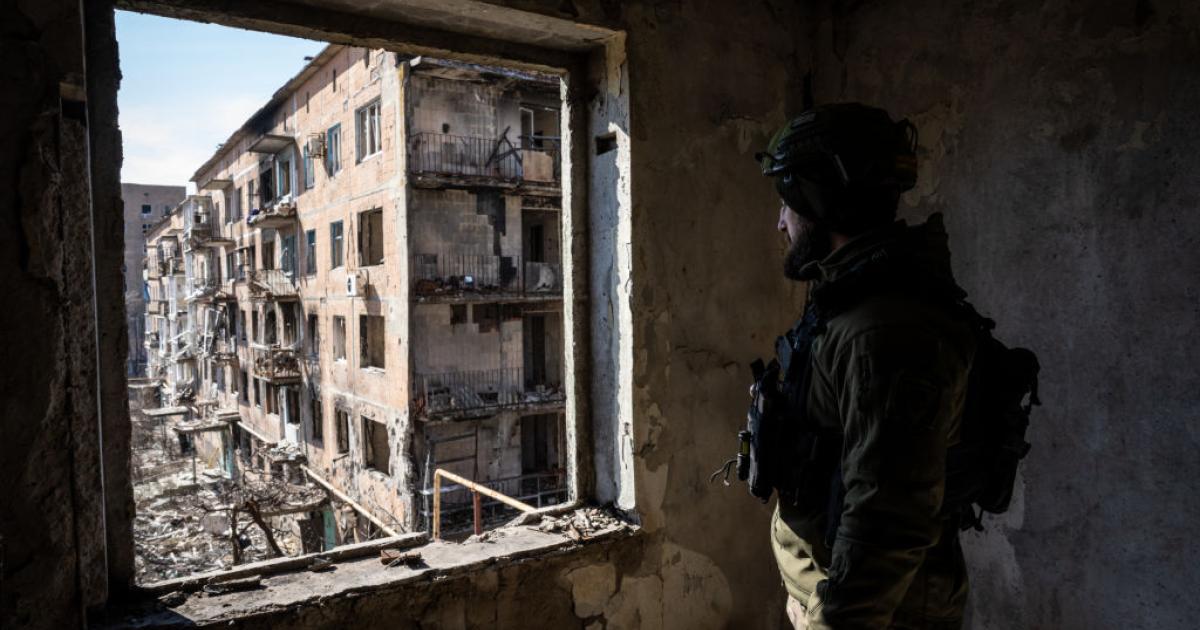 Un soldado ucraniano patrulla los edificios destruidos en la ciudad de Vuhledar