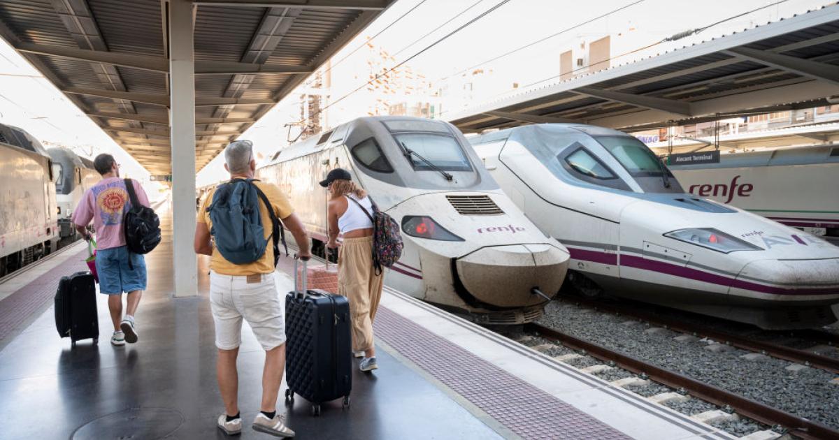 Un grupo de pasajeros se dirige a un tren de Renfe estacionado en la estación de Alicante.