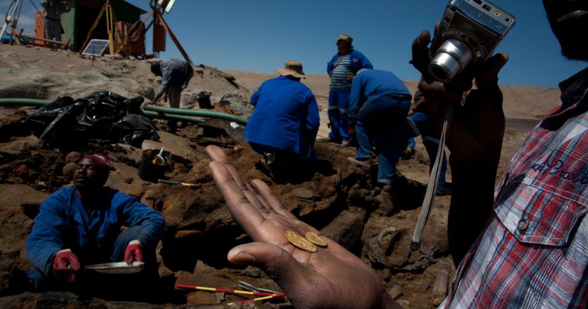 Una persona sostiene algunas de las monedas halladas.