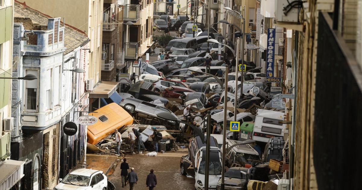 Vehículos amontonados en una calle tras las intensas lluvias de la fuerte DANA en Picaña, Valencia.