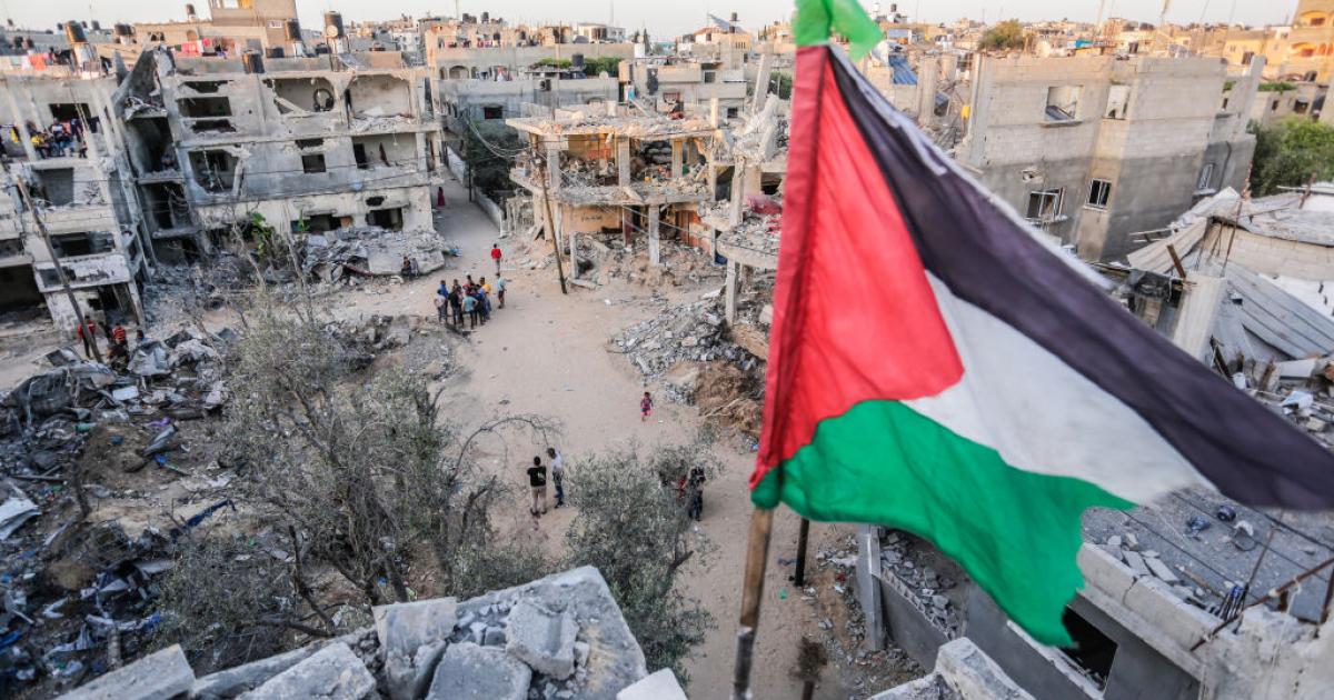 Bandera palestina en lo alto de un edificio en una zona de Gaza devastada por las bombas