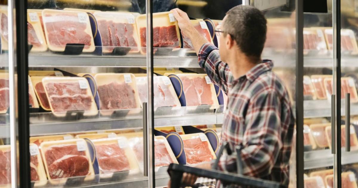 Hombre compra carne en supermercado