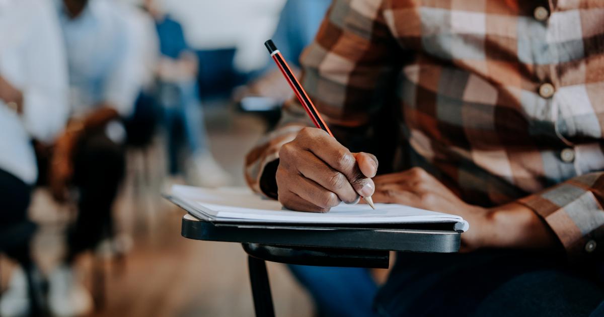 Un alumno redacta en clase.