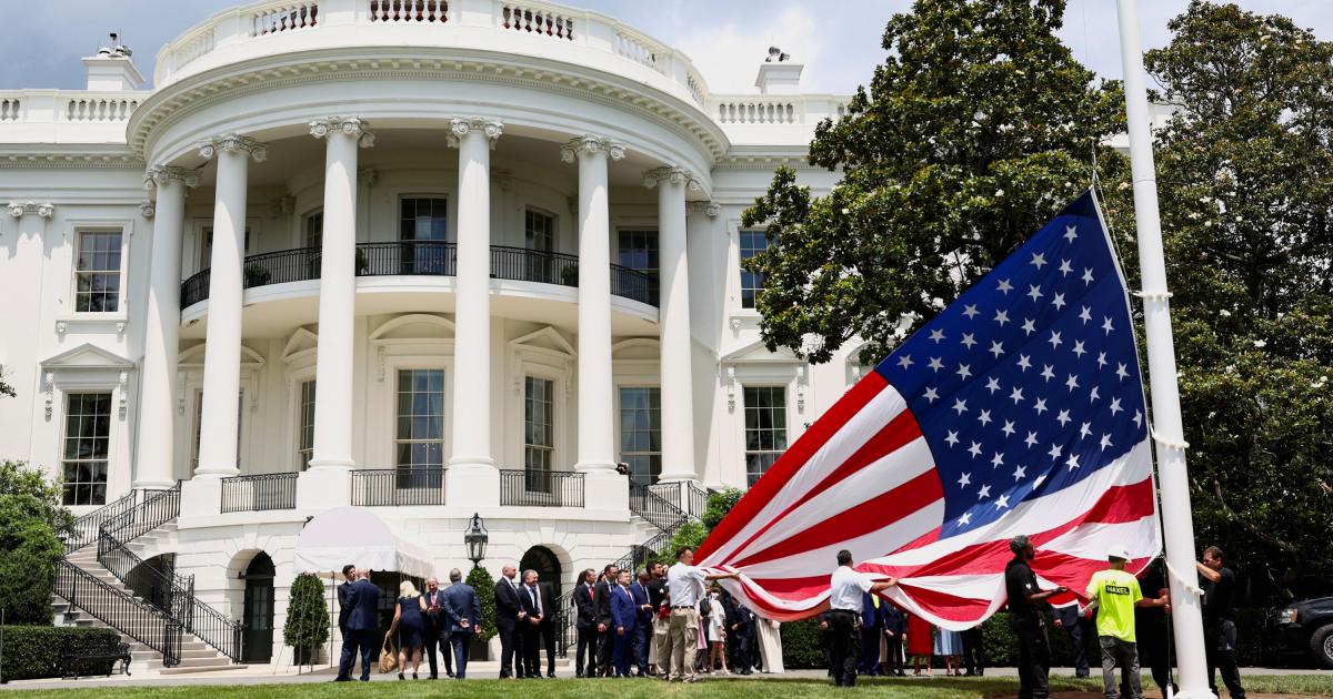 Izado de una bandera de Estados Unidos en los jardines de la Casa Blanca.