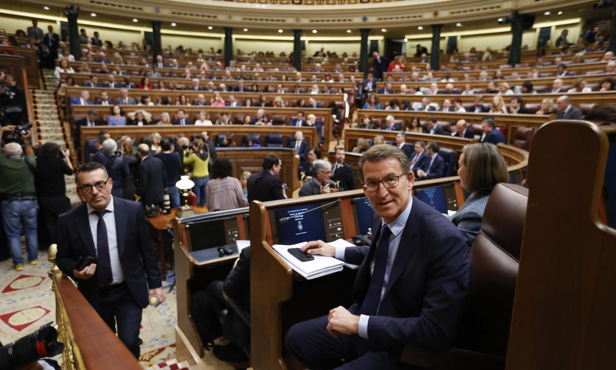 El líder popular, Alberto Núñez Feijóo, toma asiento en su escaño en el Hemiciclo de cara a la celebración del primer día del debate de investidura del líder del PSOE, Pedro Sánchez.