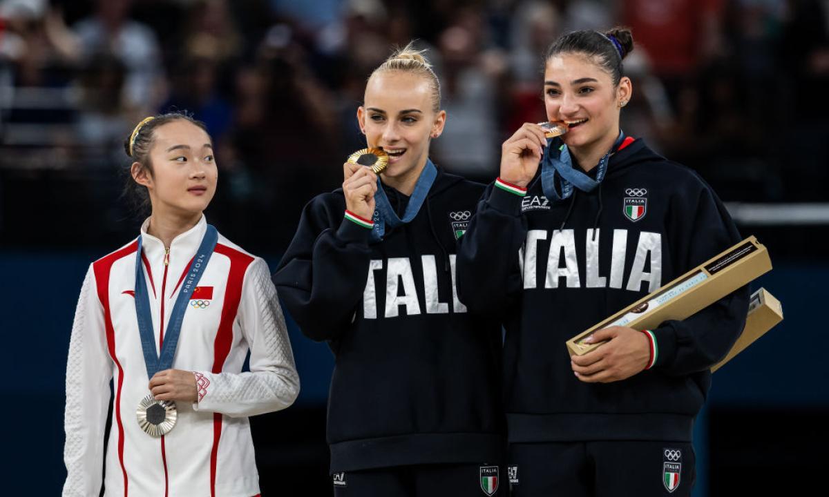 La ganadora de la plata en la barra de equilibrio, la china Yaqin Zhou of China, protagonizó una de las escenas más tiernas sobre el podio al morder su medalla, imitando el gesto de las italianas.