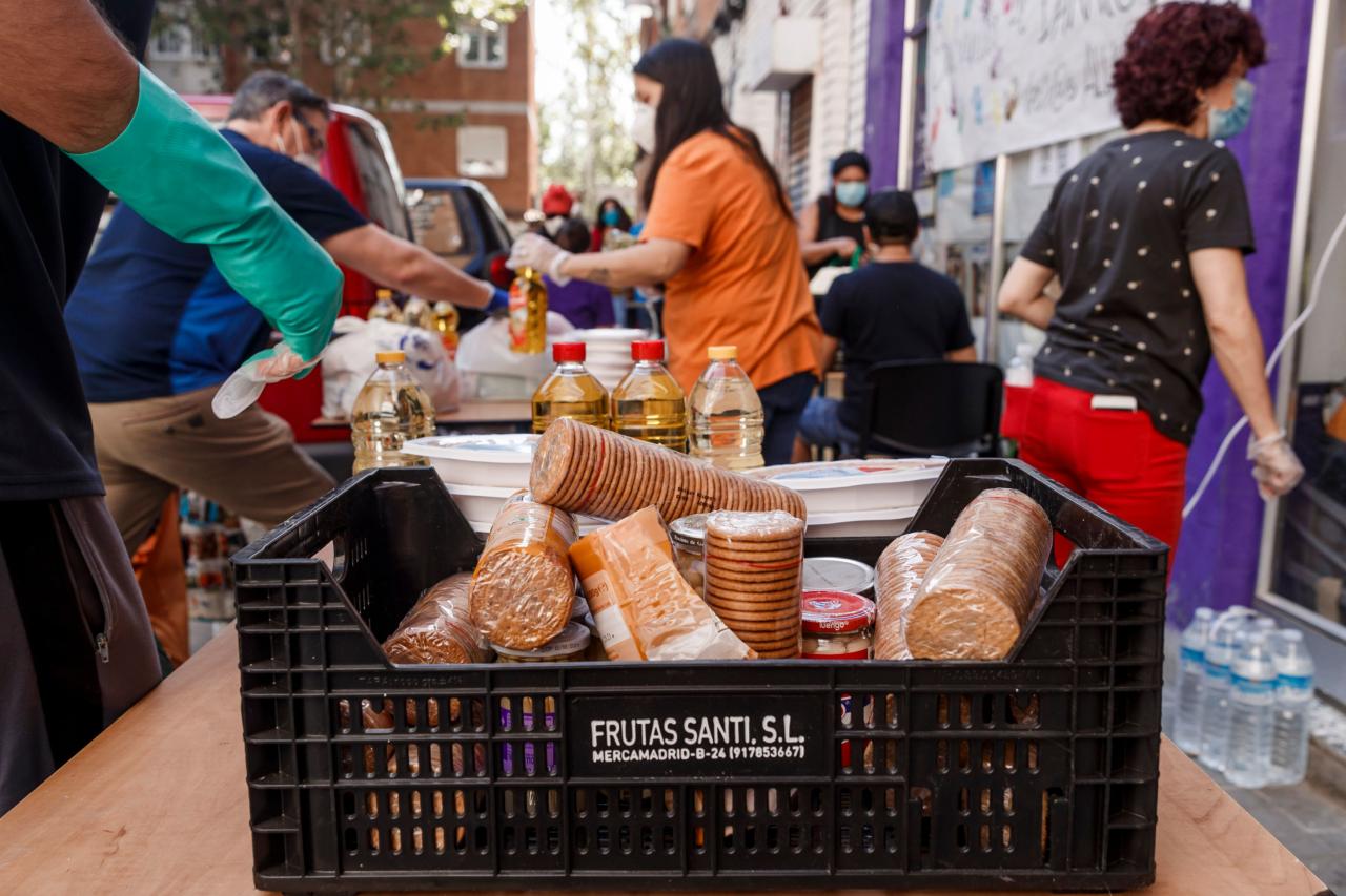 Vecinos del barrio de Aluche, en Madrid, reparten comida.