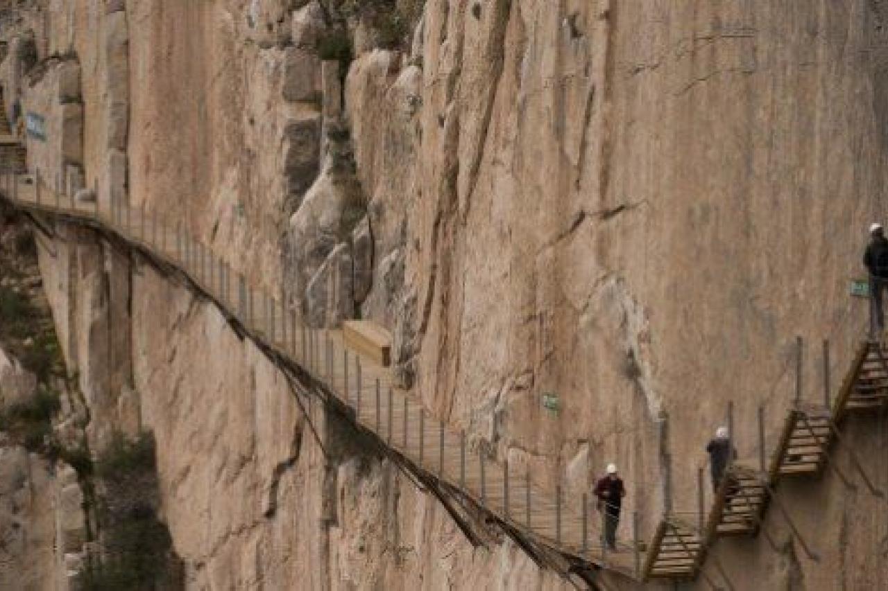 Journalists walk during a visit to the foot-path 'El Caminito del Rey' (King's little path) a narrow walkway hanging and carved on the steep walls of a defile in Ardales near Malaga on March 15, 2015. The one meter wide and 7.7 km long path, han...