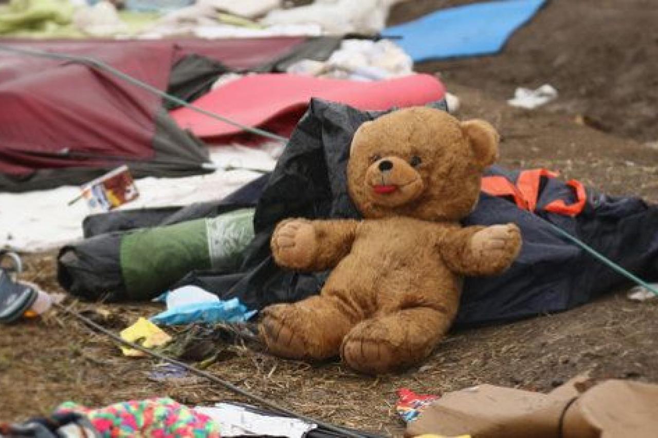 ROSZKE, HUNGARY - SEPTEMBER 14:  (EDITOTS NOTE: This image was processed with digital filters) A teddybear, tents and clothing lays on the ground as migrants discard items no longer wanted or needed  when they cross the Hungarian border on Septe...