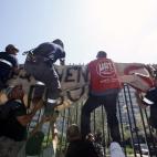 Un grupo de mineros colocan una pancarta en la verja del Ministerio de Industria durante la protesta.