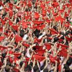 Cientos de personas levantan sus pañuelos rojos durante el lanzamiento del chupinazo.