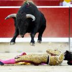 El tercer novillo de la tarde salta por encima del novillero madrileño Noé Gómez, tras recibirlo a portagayola en la plaza de toros de Pamplona en la primera de abono de la Feria de San Fermín.