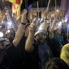 Los mineros marchan de noche por el centro de Madrid con sus linternas encendidas.