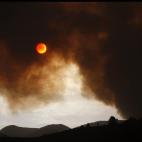 La luna aparece tapada parcialmente por el fuego en Tijoco Bajo (Tenerife)