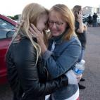 Emma Goos, 19, hugs her mother, Judy Goos, outside Gateway High School where witnesses were brought for questioning Friday, July 20, 2012, in Aurora, Colo. Emma was in the third row of the theater of the new Batman movie when the shooter entered...