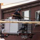 Police break out a window of an apartment where the suspect in a shooting at a movie theatre lived in Aurora, Colo., Friday, July 20, 2012. As many as 12 people were killed and 50 injured at a shooting at the Century 16 movie theatre early Frid...
