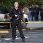 A SWAT team officer stands watch near an apartment house where the suspect in a shooting at a movie theatre lived in Aurora, Colo., Friday, July 20, 2012. As many as 14 people were killed and 50 injured at a shooting at the Century 16 movie thea...