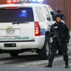 A SWAT team officer stands watch near an apartment house where the suspect in a shooting at a movie theatre lived in Aurora, Colo., Friday, July 20, 2012. As many as 12 people were killed and 50 injured at a shooting at the Century 16 movie thea...