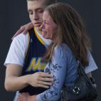 Jacob Stevens, 18, hugs his mother Tammi Stevens after being interview by police outside Gateway High School where witness were brought for questioning after a shooting at a movie theater, Friday, July 20, 2012 in Denver. A gunman wearing a gas ...