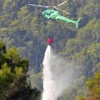 Un helicóptero descarga agua en un bosque de la localidad de Boadella