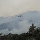 Un helicóptero lanza agua sobre las llamas que asolan los alrededores de La Jonquera.