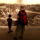 Una mujer y su hijo observan una imagen de cómo quedó la ciudad tras la explosión nuclear en el museo situado dentro del Parque de la Paz de Hiroshima.
