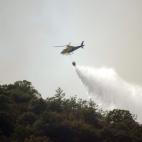 Un helicóptero del Plan de Prevención y Extinción de Incendios Forestales de Castilla-La Mancha (Infocam) lanza agua sobre una zona del incendio del Parque Nacional de Cabañeros